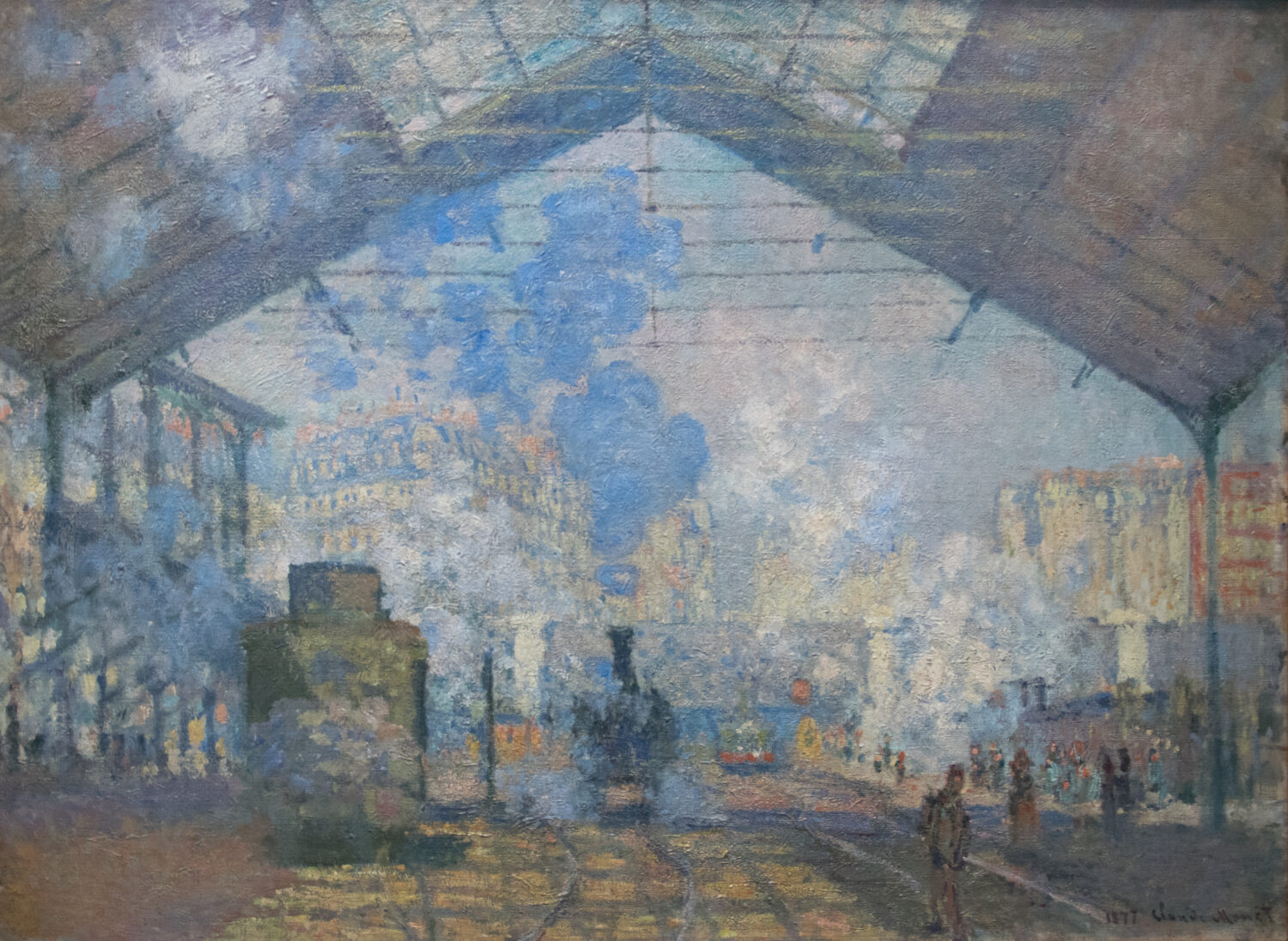 Gare Saint Lazare by Claude Monet, with a locomotive and travelers beneath the station roof amid blue-gray steam.