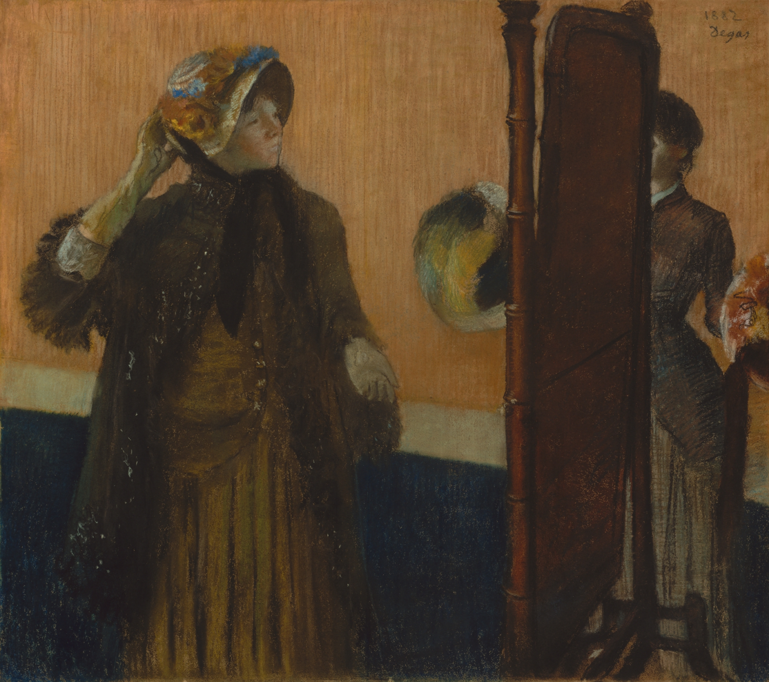 A woman adjusts a decorated hat beside a tall mirror, with another figure partly visible beyond it.