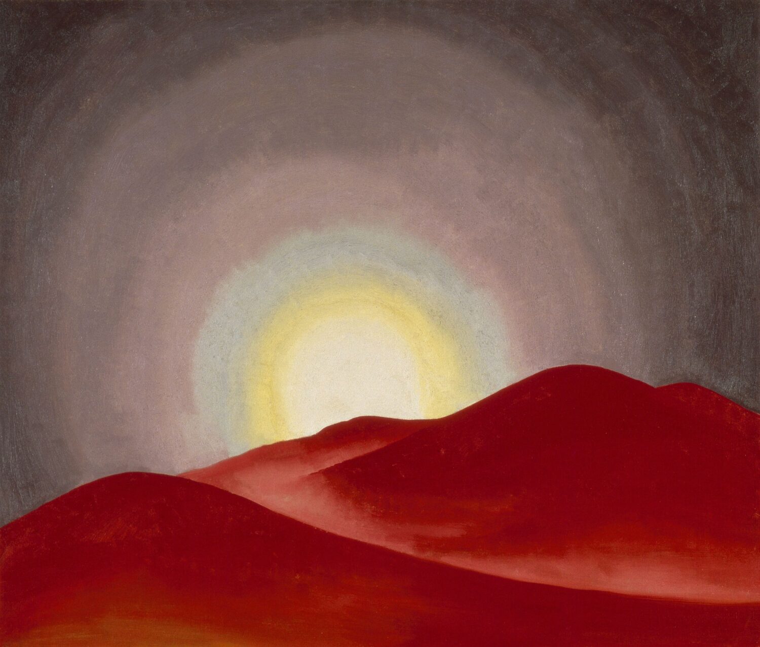 Red Hills, Lake George by Georgia O’Keeffe, with rolling red hills beneath a glowing sun