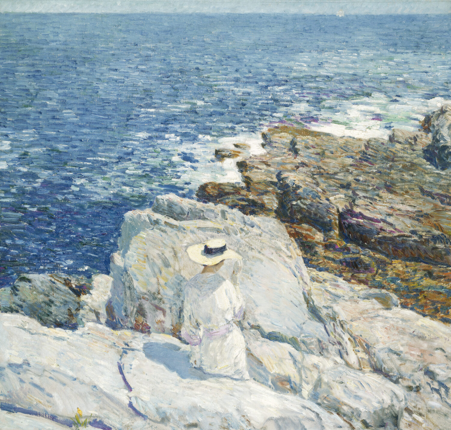 A woman in a sunhat seated on bright coastal rocks above blue water in The South Ledges, Appledore by Childe Hassam